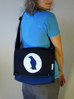 A photograph of an overshoulder handbag made of heavy nylon fabric with a crow as sewn by Aramee Diethelm