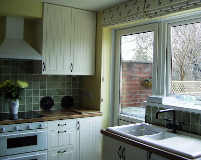 Mike and Rosie's white, green and yellow kitchen with touches of black and blue.