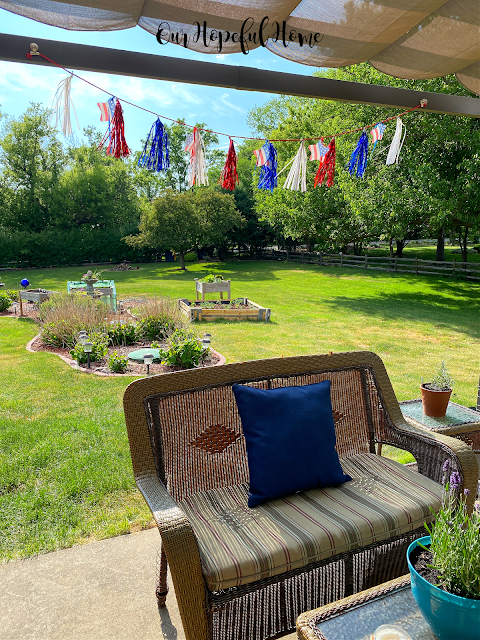 patriotic garland hanging over patio bench