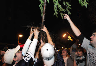 Penn State fans worship a tree they tore out of the ground during celebrations after beating Ohio State