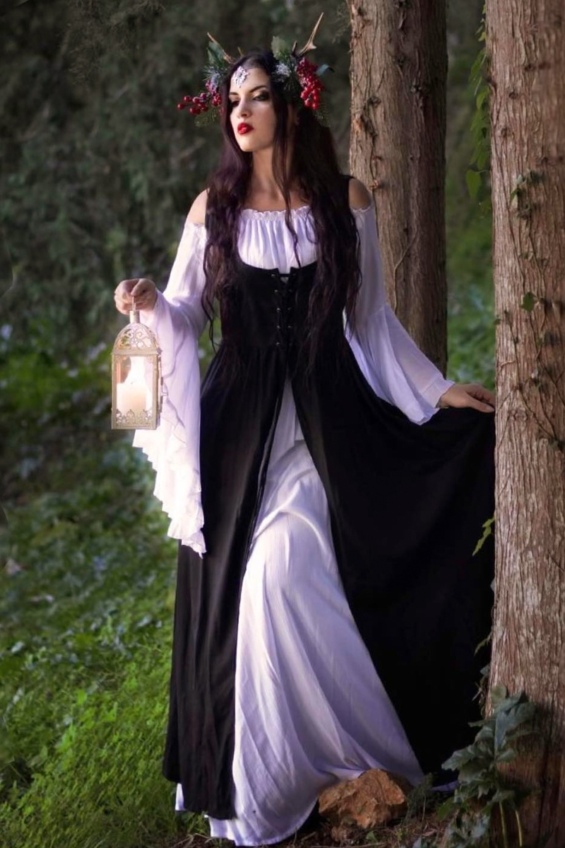 beautiful young woman in a witchy outfit is posing for the camera