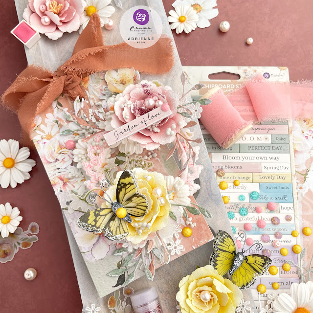 Handmade mixed media tag created with the Prima Marketing In Full Bloom collection, featuring chiffon ribbon, paper flowers, ephemera, chipboard sticker, say it in crystals, and a butterfly