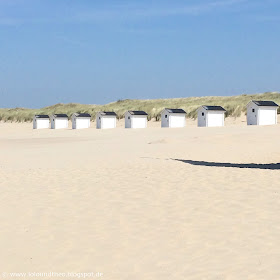 Weiße Strandhütten vor Düne