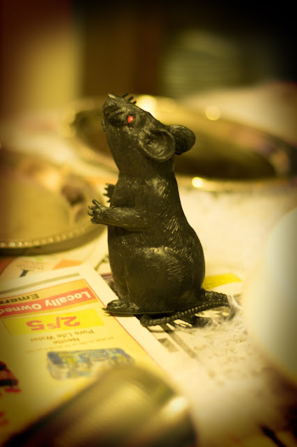 A picture of a plastic rat on the table.  