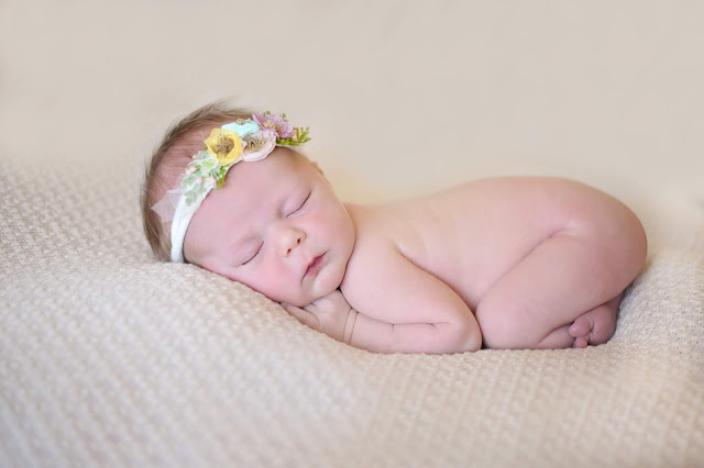 newborn girl on beige blanket