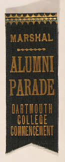 A dark green ribbon with gold text reading "Marshal Alumni Parade Dartmouth College Commencement."