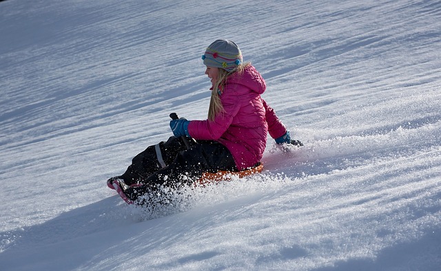 Child Snowboarding Down a Snowy Slope