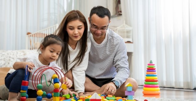 Parents playing with educational toys with their daughter