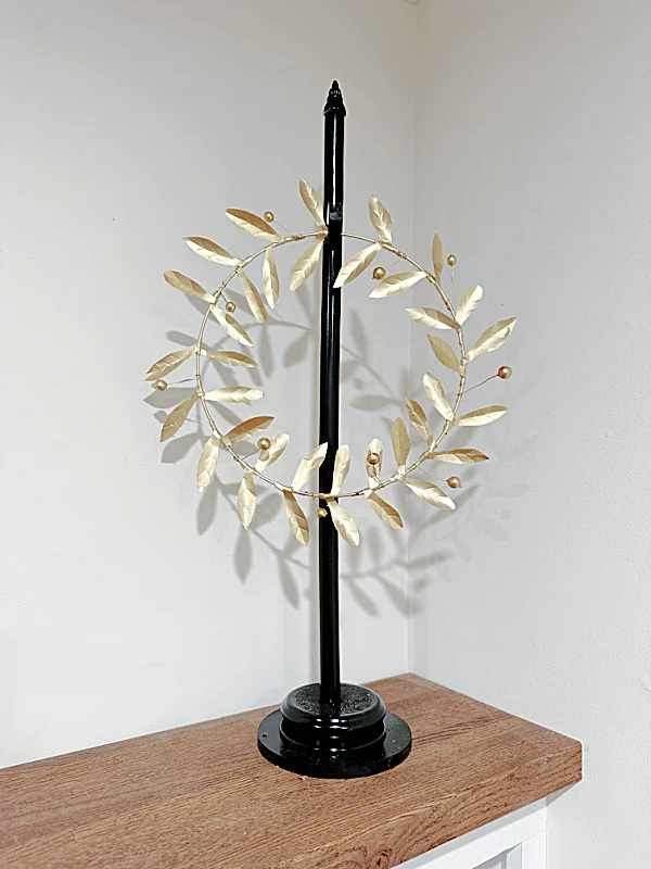 gold metal wreath on stand