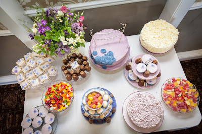 Colourful cake table with walnut whips, sweets, fondant fancies and various cakes