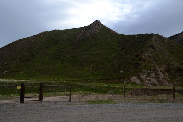 trail crossing green of a steep hill side