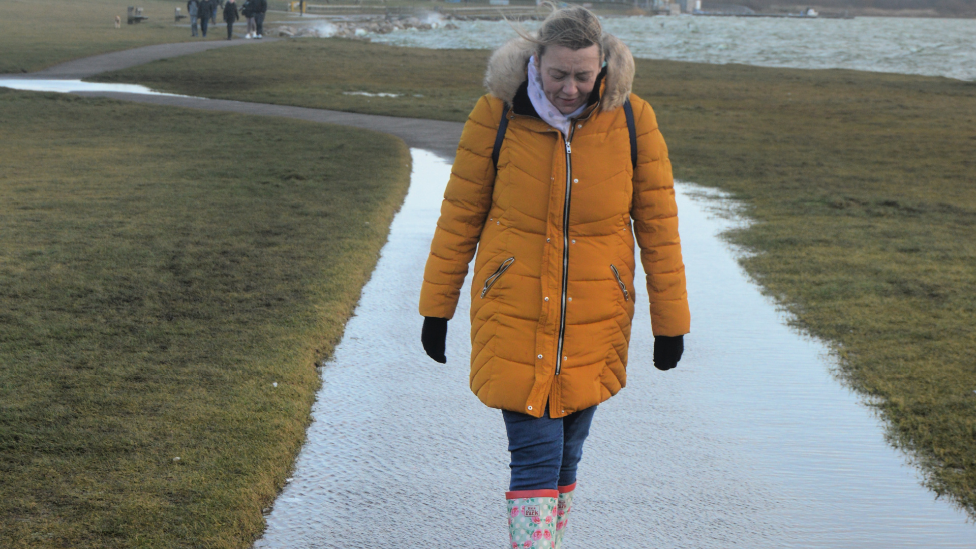 a woman walking through a puddle