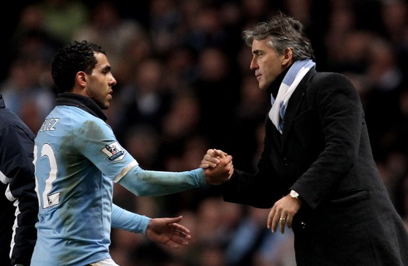 Carlos Tévez shakes hands with manager Roberto Mancini after being substituted