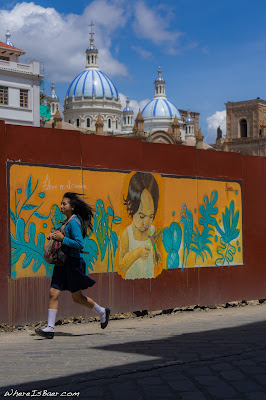 old meets new in Cuenca, young girl running in city graffiti, foreground back ground blue top church art, WhereIsBaer.com Chris Baer