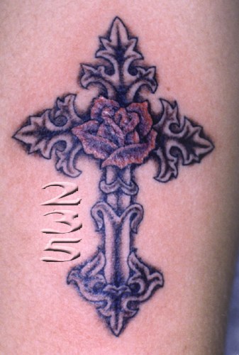 Intricately decorated Christian cross tattoo.