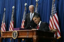 President Barack Obama signs the $787 billion economic stimulus bill, as Vice President Joe Biden watches