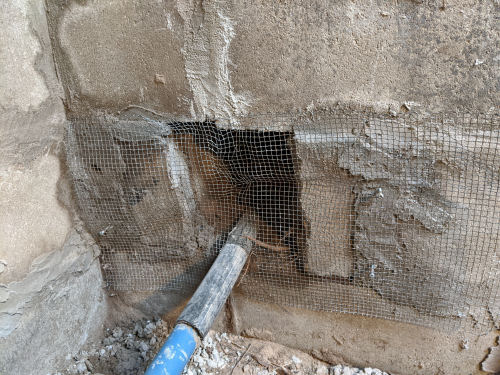 hardware cloth over an opening in a well pit