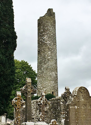 Round tower rising above the Celtic crosses at Monasterboice Monastery, Boyne River Valley, Ireland