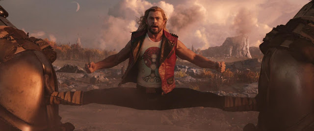 Image of Thor doing the splits between two objects, from the film Thor Love And Thunder