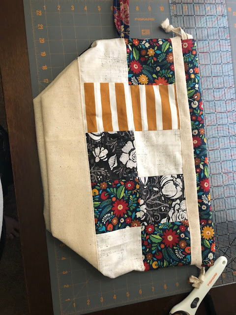Sewn patchwork project bag. There are floral prints and stripes.