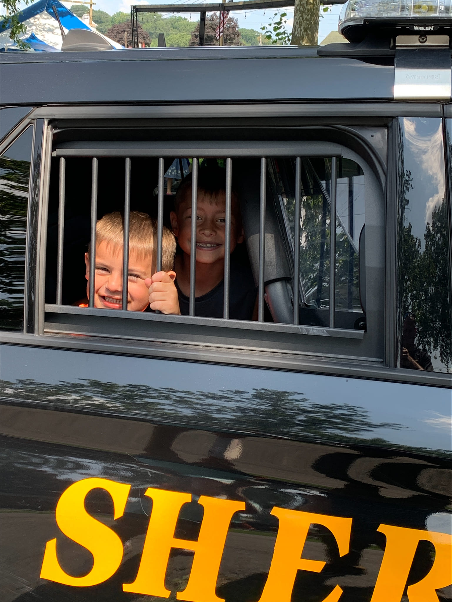 children in back of sheriff car