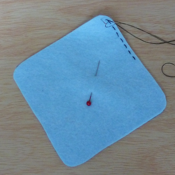 Sewing running stitch around the corner edge of felt