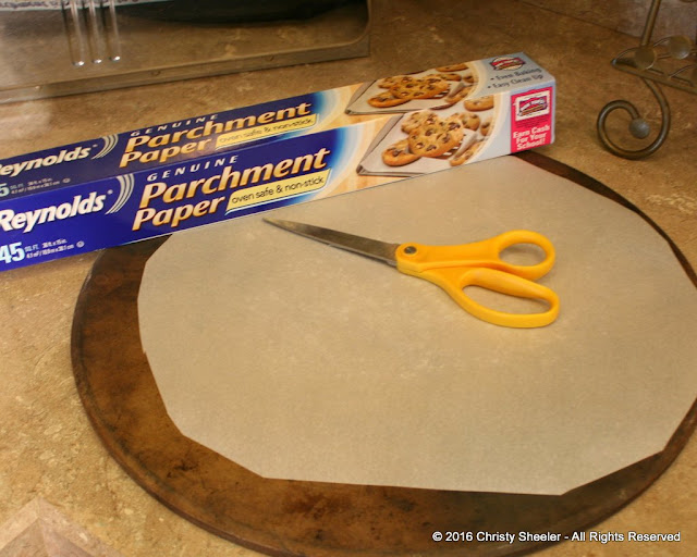 Parchment paper trimmed an inch smaller diameter than pizza stone.