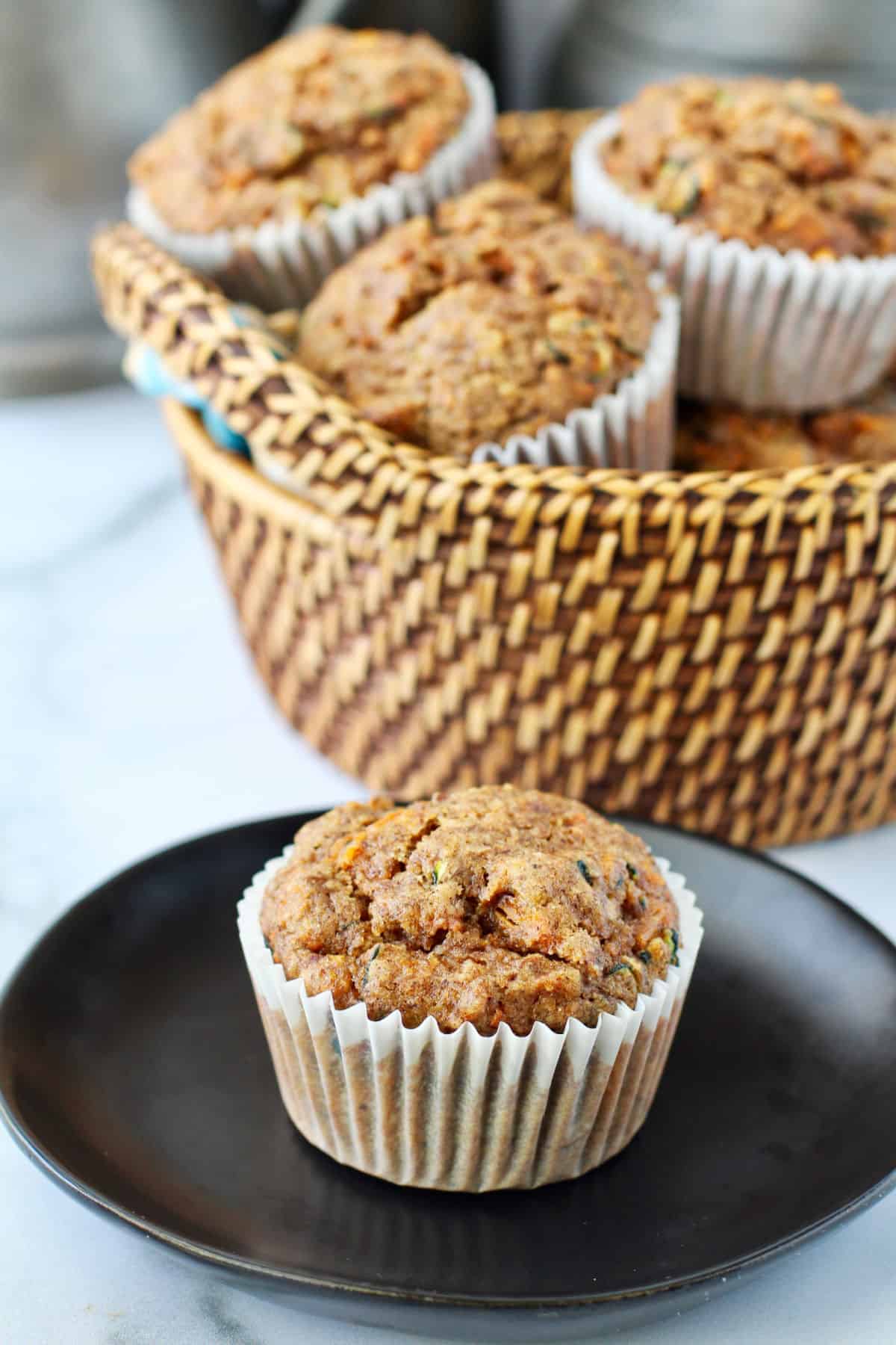 Zucchini Carrot Muffins on a black plate.