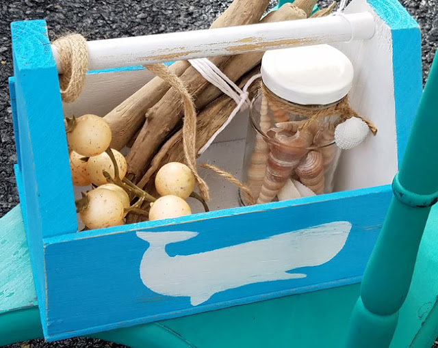 caddy with wall print on the outside and seashells with driftwood