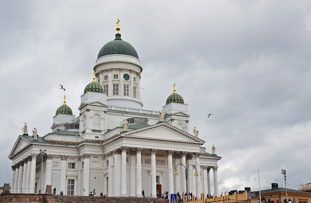  foto da Catedral Luterana de Helsinque com suas colunas e pardes toda branca e cúpulas verde musgo  