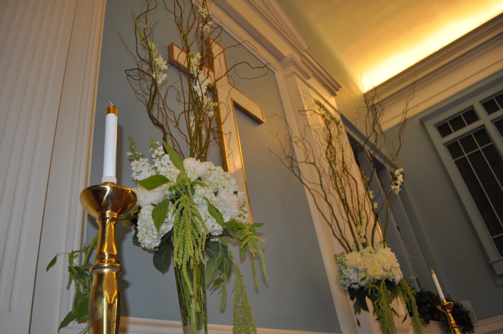 Two white and green designs with curly willow stood at the altar 