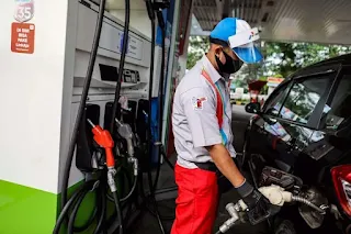 Petugas SPBU yang sedang melayani saat pengisian bahan bakar jenis Pertalite