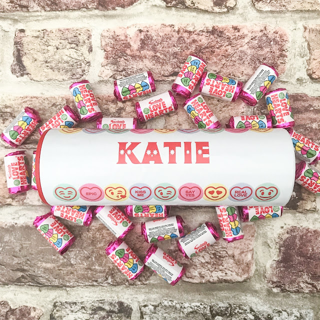 Tube designed to look like a large love heart tube with the name Katie across the centre, surrounded by small love heart sweets