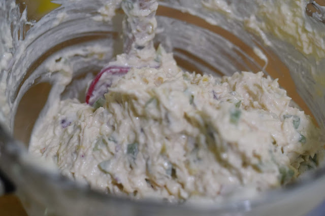 The chicken, celery, onion, relish, and mayonnaise mixed together in a bowl.