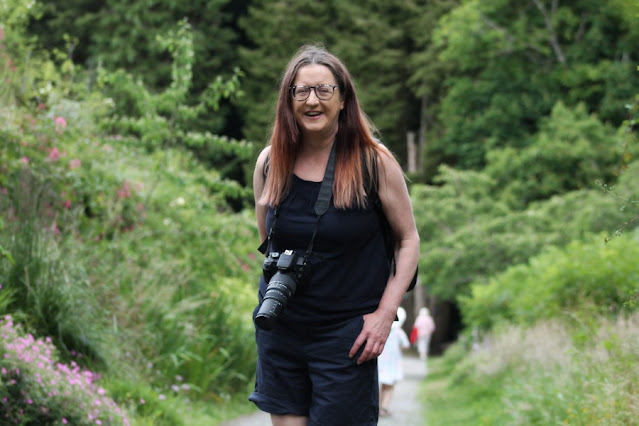 Picture of Cliona standing on path with camera and woodland in the background