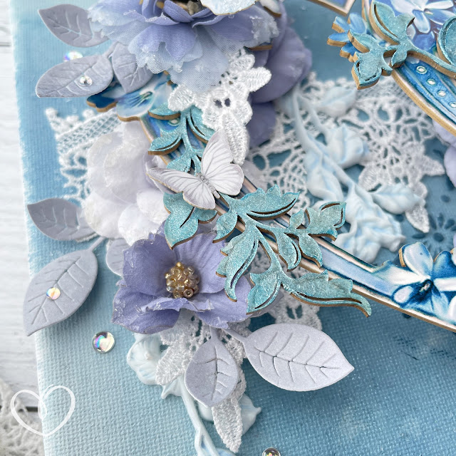 Rhapsody in Blues mixed media canvas created with: Reneabouquets ice fairy butterflies, sweet pea baby blue butterfly, fairy dust butterfly kisses, drop lace, diamond glitter glass, elegant accents chipboard, blue lilac heart frames beautiful board; Prima Marketing the plant department flowers; Tim Holtz distress sprays