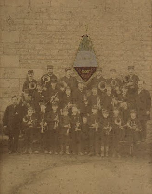 Première photographie de la Fanfare des Ecoles Laïques-les Amis Réunis, prise à Montceau en 1887, devant l’école de la rue de l’Est, actuel musée (collection particulière)