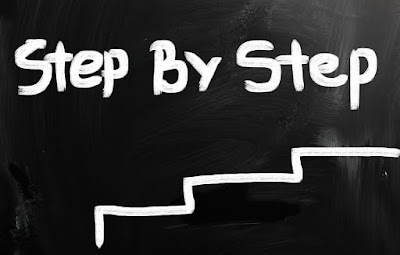 On a blackboard are the words "Step by Step" with a simple drawing of steps beneath