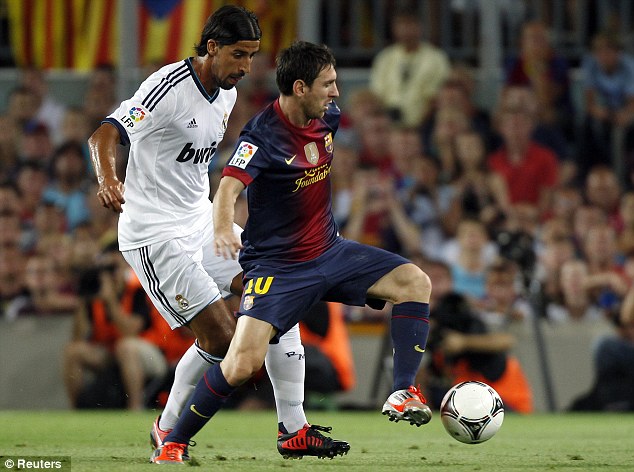 Lionel Messi on the ball with Sami Khedira.