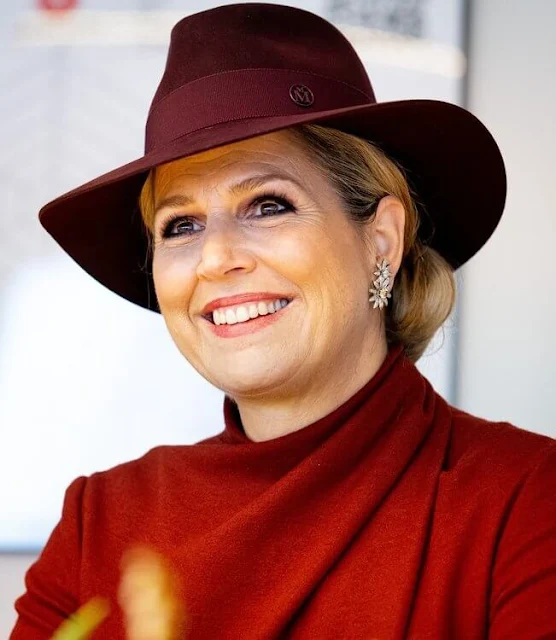 Queen Maxima wore a red midi dress from Natan. The Queen wore a new burgundy hat by Maison Michel Paris