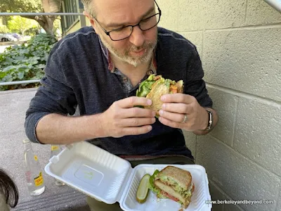 vegan eating a Killer B.L.A.T. sandwich from The Butcher's Son in Berkeley, California