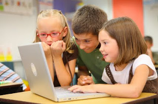 Three kids on playing on a laptop