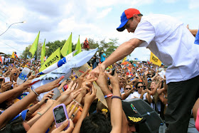 Presidential hopeful Henrique Capriles reaches out to supporters at a rally