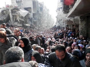 Refugiados palestinos fazem fila para recebr comida no Yarmouk