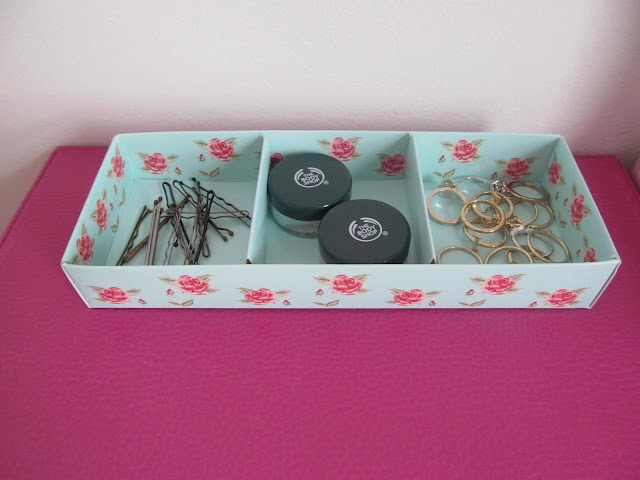 floral cardboard contrainer with kirbies in one section, tubs in the second and rings in the third