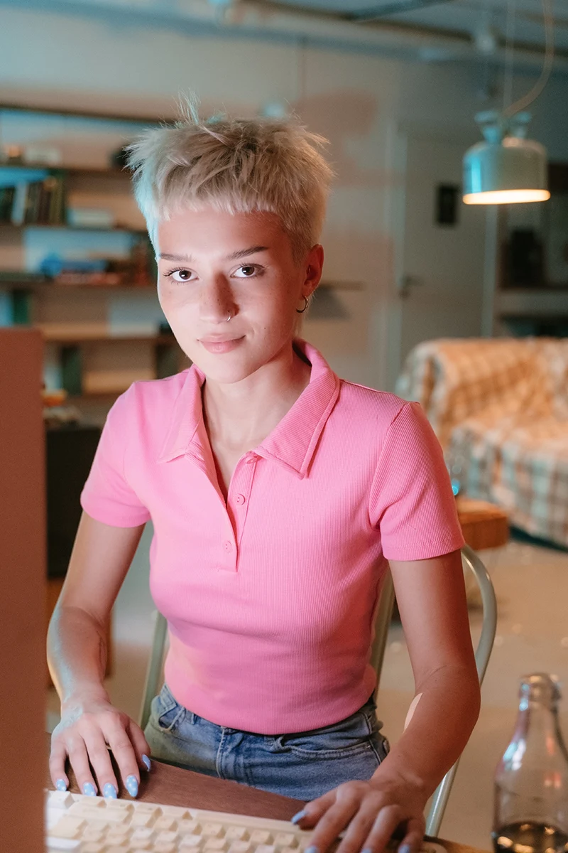 woman in a fit polo sshirt is sitting at a table in an office