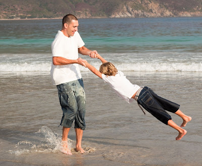 Padre e hijo disfrutando de la frescura del mar