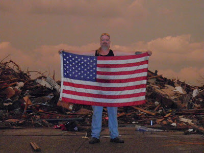 Man displays American flag amid tornado debris