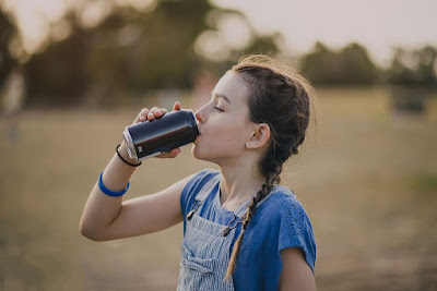 A girl is drinking cola