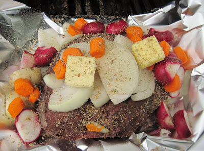 Cooking beef roast with vegetables on a grill